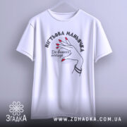 Футболка нігтьова маньячка, білого кольору, підвішена на вішалці, фон світло-сірий, принт з рукою з червоними нігтями та написом 'До ваших послуг'.