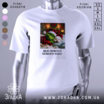 Футболка новорічний грінч білого кольору, зображена на манекені, фон світлий, принт з грінчем і собакою в новорічних шапках, текст "Щасливого Нового Року" під малюнком.