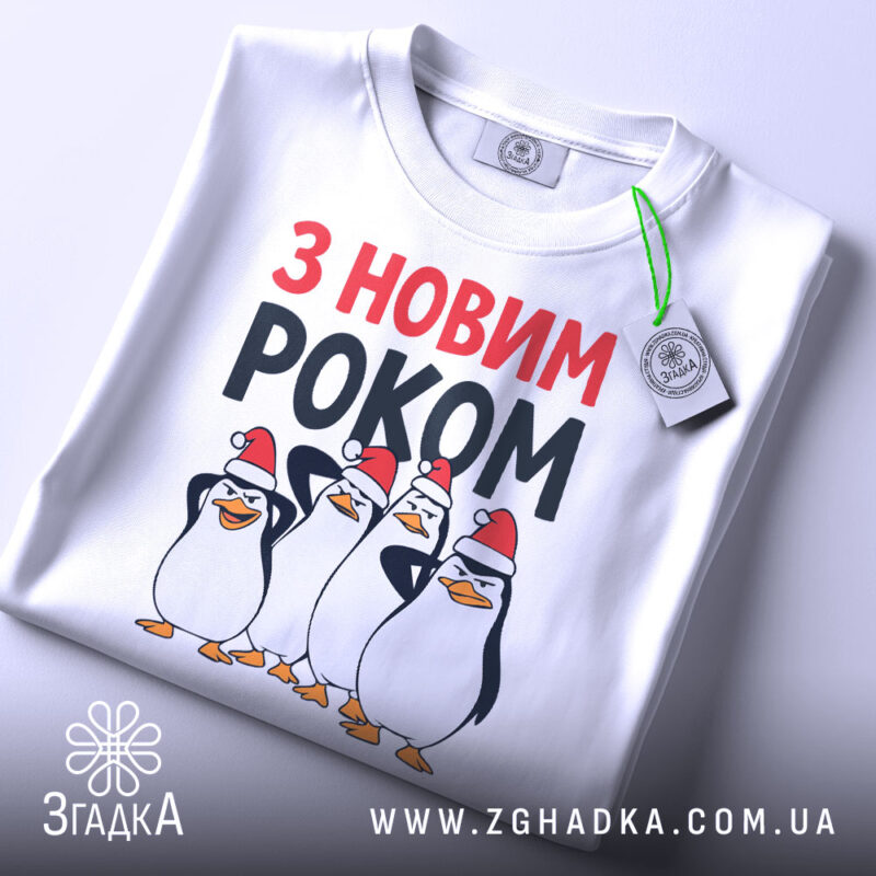 Футболка новий рік пінгвіни, біла, з верхнього ракурсу, на столі, фон світлий, принт з чотирма пінгвінами у червоних новорічних шапках, текст 'З НОВИМ РОКОМ' у червоному та чорному кольорах, з зеленим ярликом.