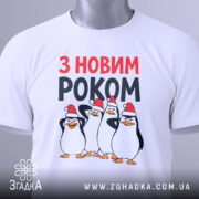Футболка новий рік пінгвіни, біла, з верхнього ракурсу, на столі, фон світлий, принт з чотирма пінгвінами у червоних новорічних шапках, текст 'З НОВИМ РОКОМ' у червоному та чорному кольорах, з зеленим ярликом.