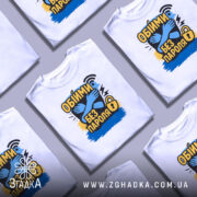 Футболка обійми без пароля, білого кольору, зображена на манекені, фон світло-сірий, принт містить зображення обіймів, текст "Обійми без пароля" в жовтому та чорному кольорах, з елементами синього та чорного фону.