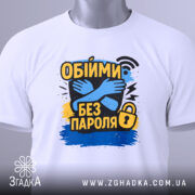 Футболка обійми без пароля, білого кольору, складена на поверхні, фон світло-сірий, принт з обіймами та текстом "Обійми без пароля" в жовтому, чорному та синьому кольорах, на футболці є етикетка з зеленим шнурком.