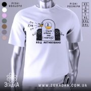 Футболка один крякає. Біла футболка на манекені, з принтом у вигляді качки, що крякає, на чорному фоні. Принт містить текст "Один крякає – інші мовчать!" та "КОД АКТИВОВАНО".