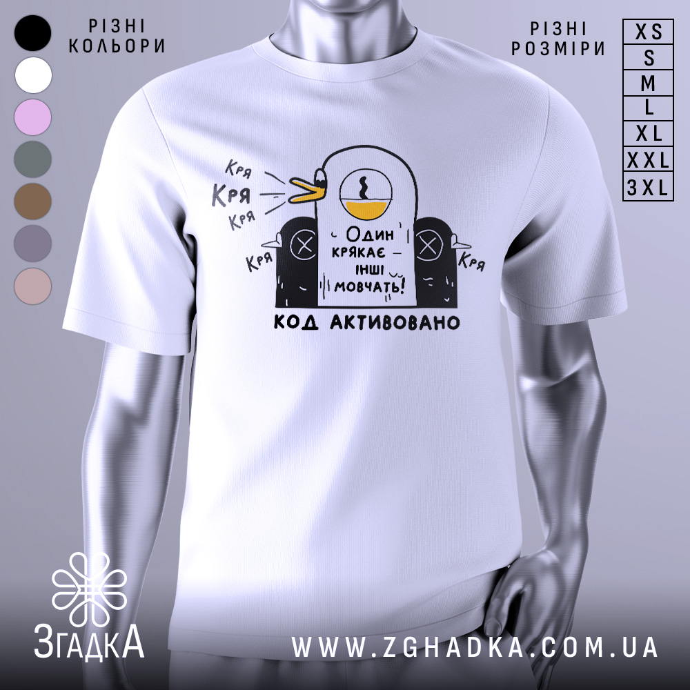 Футболка один крякає. Біла футболка на манекені, з принтом у вигляді качки, що крякає, на чорному фоні. Принт містить текст "Один крякає – інші мовчать!" та "КОД АКТИВОВАНО".