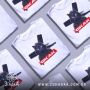 Футболка окак мем подарунок, кілька складених білих футболок з принтом чорного кота в капюшоні, на фоні світло-сірого кольору.