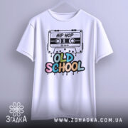 Футболка Old School білого кольору, підвішена на вішалці, фон нейтральний, принт з касетою та написом 'OLD SCHOOL' у яскравих кольорах.