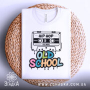 Футболка Old School білого кольору, складена на плетеній основі, фон світлий, принт з касетою та написом 'OLD SCHOOL' у яскравих кольорах.