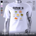 Футболка олів`є набір білого кольору, зображена на манекені з правого боку, фон світло-сірий, принт містить малюнки овочів та інгредієнтів олів`є, текст чорного кольору: 'ОЛІВ`Є СТАРТОВИЙ НАБІР'.
