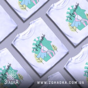 Футболка Party на хаті, біла, зображена з правого ракурсу, фон світло-сірий, принт з малюнком хлопця в капелюсі з синім плащем та шортах з сердечками, напис 'Party' зверху.