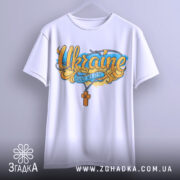 Футболка патріотична Україна, біла, підвішена на вішалці, фон світло-сірий, принт з написом 'Ukraine' та жовто-блакитними елементами, видно деталі рукавів.