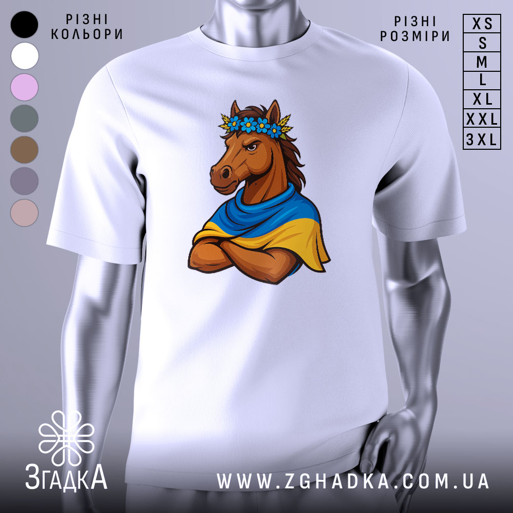 Futbolka Patriotychnyi Kin Styl Ta Emotsiia 1 Футболка патріотичний кінь, біла, зображена на манекені, фон світло-сірий, принт з кінем у вінку з квітів та синьо-жовтому шарфі, кінь з серйозним виразом обличчя, руки схрещені на грудях.