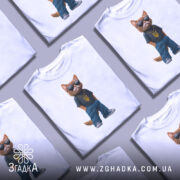 Футболка патріотичний кіт, біла, зображена з фронтального ракурсу, на фоні світло-сірого градієнту, принт з котом у темній футболці з жовтим гербом України та синіх штанах, в темних окулярах і золотому ланцюгу.