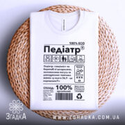 Футболка педіатр білого кольору, зображена зверху на плетеній основі, фон нейтральний, принт містить текст і графічні елементи, з написом '100% ECO'.