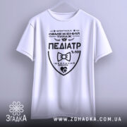 Футболка педіатр білого кольору, підвішена на вішалці, фон світло-сірий, принт чорного кольору з написом 'ПЕДІАТР' та графічними елементами.