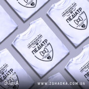 Футболка педіатр білого кольору, зображена з правого ракурсу на манекені, фон світло-сірий, принт чорного кольору з написом 'ПЕДІАТР' та графічними елементами.