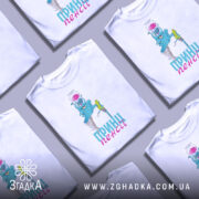 Футболка пенсійний жарт, біла, зображена з фронтального ракурсу на манекені, фон світло-сірий, принт з малюнком блакитного персонажа з банкою на голові та написом 'ПРИН!!! пенсії' у рожевому кольорі.