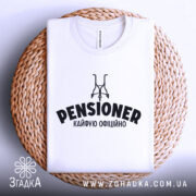 Футболка пенсіонер кайфую, біла, зображена зверху на плетеній основі, на фоні світло-сірого кольору, з принтом чорного кольору, що містить слово 'PENSIONER' та малюнок візка.