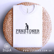 Футболка пенсіонер ще рухаюсь, біла, складена на плетеній основі, з верхнього ракурсу, фон світло-сірий, принт чорного кольору з написом 'PENSIONER' та малюнком людини з палицею.