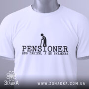 Футболка пенсіонер ще рухаюсь, біла, складена на поверхні, з верхнього ракурсу, фон світло-сірий, принт чорного кольору з написом 'PENSIONER' та малюнком людини з палицею, на ярлику зелена стрічка.