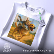 Футболка пес кота везе, біла футболка на столі, зображення кота на спині собаки з рибою, фон - світлий, деталі принта чіткі, на футболці є етикетка.