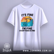 Футболка песик все добре. Біла футболка, підвішена на вішалці, з ракурсу спереду. Фон світло-сірий, принт яскравий, з собакою на сміттєвому контейнері, текст "IT'S FINE I'M FINE EVERYTHING IS FINE".