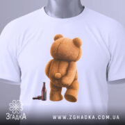 Футболка п’яний ведмідь, біла, зображення ведмедя з пляшкою, ракурс зверху, фон світлий, принт ведмедя з пухнастою текстурою, з етикеткою.
