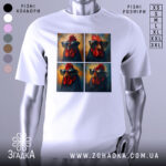 Футболка півень зухвалий, біла, зображена з фронтального ракурсу, на фоні світло-сірого кольору, принт складається з чотирьох зображень півня в окулярах, з яскравими червоними гребінцем і яскравими кольорами.