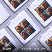 Футболка півень зухвалий, біла, зображена з фронтального ракурсу, на фоні світло-сірого кольору, принт складається з чотирьох зображень півня в окулярах, з яскравими червоними гребінцем і яскравими кольорами.