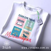 Футболка план мільйонерки, біла, зображена з верхнього ракурсу, фон світлий, на футболці принт з чотирьох кольорових квадратів, текст та малюнки, напис 'Мільйонерка' червоним шрифтом, на футболці також є етикетка.