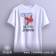 Футболка подарунок душнілі, біла, зображена з фронтального ракурсу на вішалці, фон світло-сірий, принт з малюнком вікна з червоною стрічкою та написом 'ЦЕ ТОБІ, ДУШНІЛА'.