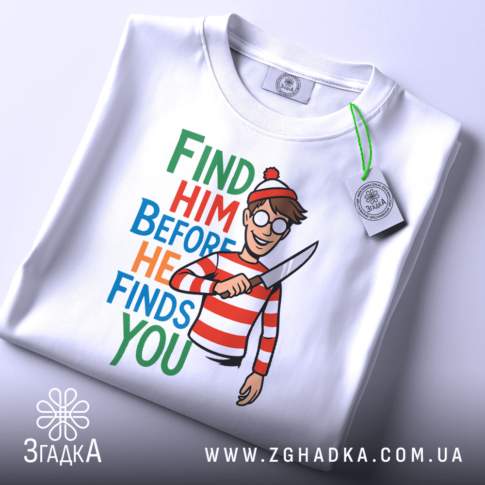 Футболка полювання на Воллі, біла, складена на столі, фон світло-сірий, принт з написом 'FIND HIM BEFORE HE FINDS YOU' та малюнком персонажа у червоно-білу смужку з ножем у руці, на комірці є етикетка.