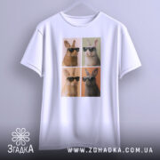 Футболка попарт кролики, біла, підвішена на вішалці, фон градієнтний сірий, принт з чотирма кроликами в окулярах, два з них коричневі, два світлі, кожен в окремій секції.