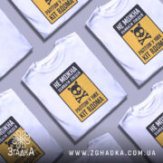 Футболка попередження про кота, біла, зображена на манекені, фон світло-сірий, принт з чорним написом і жовтим фоном, з малюнком кота і кісток.