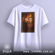 Футболка портрет українські класики, біла, зображення розташоване по центру, фон з теплими відтінками, принт з портретами двох осіб, один з них у темному одязі, інший у червоній сорочці з намистом, футболка висить на вішалці.