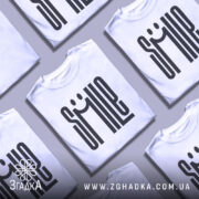 Футболка посміхнись. Біла футболка з чорним принтом, на манекені, фон світло-сірий, принт з написом 'SMILE' з усмішкою.