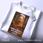 Футболка повар без мата, біла, зображена з верхнього ракурсу, фон світлий, принт з котом у кухарському капелюсі, з прикріпленою етикеткою, яка додає деталі.