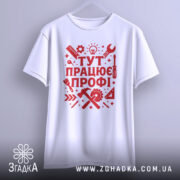 Футболка працює профі. Біла футболка з червоним принтом, зображена з фронтального ракурсу на вішалці, фон світло-сірий, принт містить інструменти та напис 'ТУТ ПРАЦЮЄ ПРОФІ!' у стилі графіки.