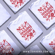 Футболка працює профі. Біла футболка з червоним принтом, зображена з фронтального ракурсу на манекені, фон світло-сірий, принт містить інструменти та напис 'ТУТ ПРАЦЮЄ ПРОФІ!' у стилі графіки.