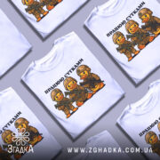 Футболка працюю сутками, біла, зображена на манекені, фон нейтральний, принт з трьома качками в камуфляжі з автоматами, текст зверху: 'ПРАЦЮЮ СУТКАМИ'.