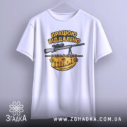 Футболка працюю віддалено, білого кольору, підвішена на вішалці, фон світло-сірий, принт з написом 'ПРАЦЮЮ ВІДДАЛЕНО' та зображенням гвинтівки і вимірювальної лінійки в жовтих і чорних кольорах.