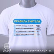 Футболка правила вчителя, біла, зображена зверху, фон нейтральний, принт з текстом правил вчителя, на футболці є етикетка з зеленим шнурком.
