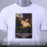 Футболка прекрасний день. Біла футболка, складена на поверхні, з принтом жінки, що тримає птаха. На футболці видно етикетку з зеленим шнурком. Принт займає центральну частину, знизу напис: 'Який прекрасний блаженний день'.