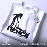 Футболка принц пенсії, біла, зображена зверху, на фоні світло-сірого кольору, принт з чорним силуетом постаті з ходунками та текстом, з біркою на комірці.