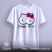 Футболка привіт ціці, біла, підвішена на вішалці, фон світло-сірий, принт з малюнком у вигляді двох круглих форм з очима та червоною бантиком, текст "Привіт Тітті" під малюнком.