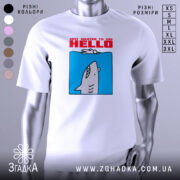 Футболка привіт від акули. Біла футболка на манекені, з принтом акули, що виглядає з блакитного фону. Текст червоним шрифтом говорить 'JUST WANTED TO SAY HELLO'. Фон нейтральний, без зайвих деталей.