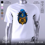 Футболка птах тризуб білого кольору, зображена з близького ракурсу на манекені, фон світлий, принт з птахом синього кольору з жовтими деталями та гербом України.