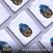 Футболка птах тризуб білого кольору, зображена з близького ракурсу на манекені, фон світлий, принт з птахом синього кольору з жовтими деталями та гербом України.