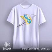 Футболка птах волі білого кольору, підвішена на вішалці, ракурс спереду, фон світло-сірий, принт з птахом у жовтих та блакитних тонах, напис 'птах волі' на стрічці.