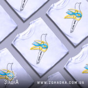 Футболка птах волі білого кольору, зображена на манекені, ракурс спереду, фон світло-сірий, принт з птахом у жовтих та блакитних тонах, напис 'птах волі' на стрічці.