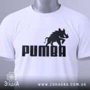 Футболка пумба пародія, біла, складена на столі, фон світлий, принт чорний з написом 'PUMBA' та силуетом борсука, на комірці є етикетка.
